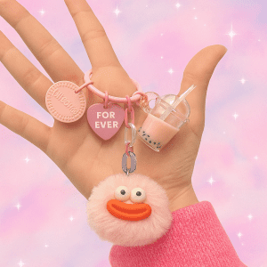 Puffy Collection keychain with plush character and surprise charm in pastel color, cute accessory on soft pink background